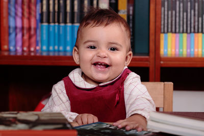 Portrait of cute baby girl on table