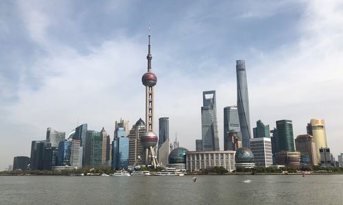 View of buildings in city against cloudy sky