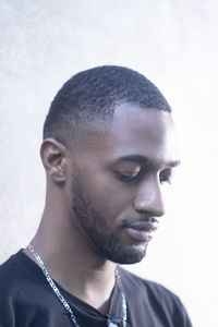 Close-up portrait of young man against wall