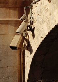 Low angle view of camera against wall