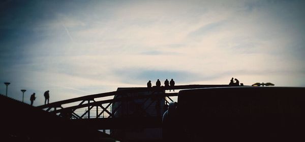 Low angle view of silhouette building against cloudy sky