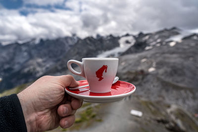 Cropped hand holding coffee cup