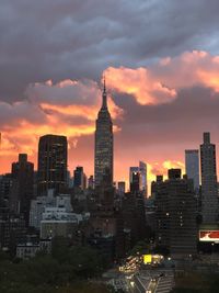 Modern buildings in city against sky during sunset