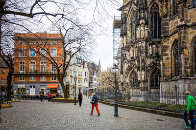 People walking on road along buildings