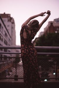 Woman standing against wall in city