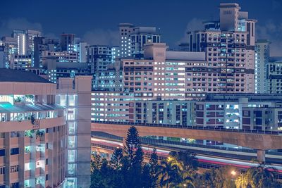 Illuminated buildings against sky at night