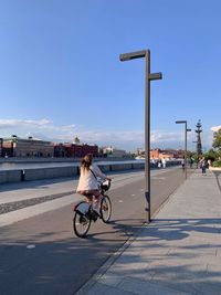 Woman riding bicycle on street in city