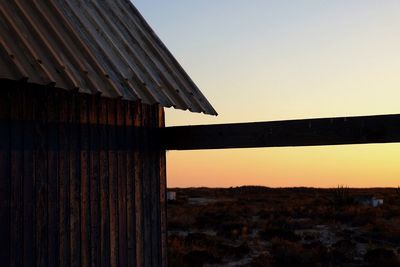 Built structure on land against clear sky during sunset