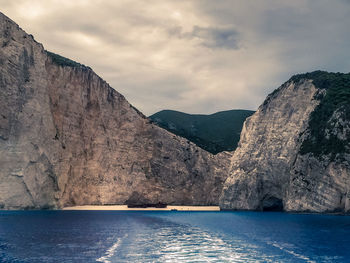 Scenic view of sea and mountains against sky