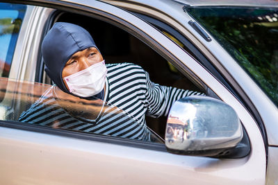 Portrait of man in car window