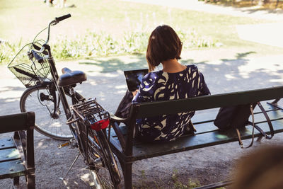 High angle view of businesswoman using digital tablet while sitting on park bench