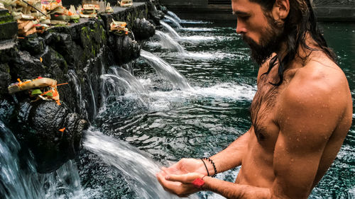 Young man splashing water in sea