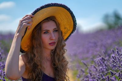 Woman in hat against flowering lavenders