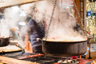 Traditional holiday food cooked and served at christmas market  during winter evening.