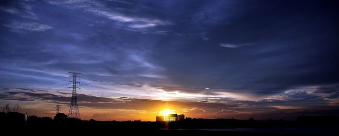 Low angle view of silhouette electricity pylon against sky during sunset