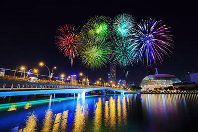 Firework display over river at night