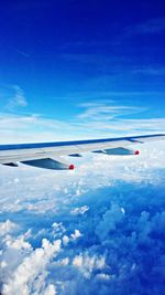 Airplane flying over clouds against blue sky