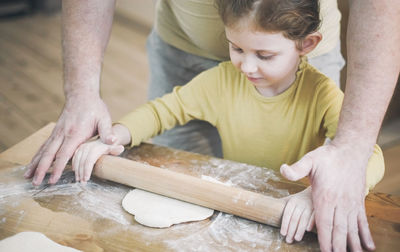 Home made child kid preparing ffod bake with parent help to father