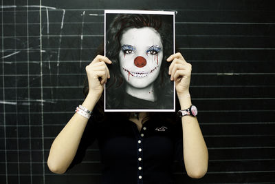 Portrait of woman holding black and white wall