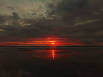 Scenic view of sea against dramatic sky during sunset