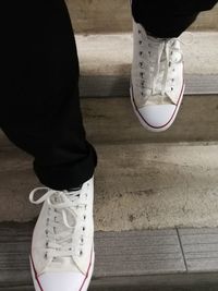 Low section of man standing on hardwood floor
