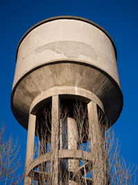 Low angle view of water tower against clear blue sky