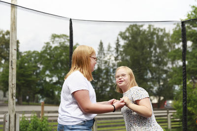 Girls holding hands on trampoline