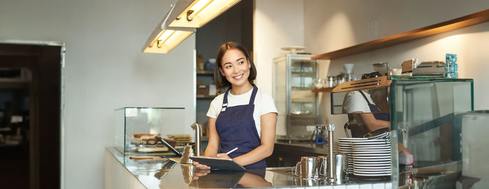 Portrait of young woman standing at home