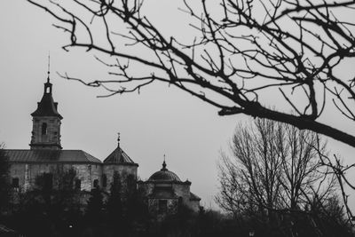 Low angle view of trees and building against sky