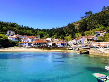 Buildings by swimming pool against clear blue sky