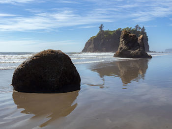 Rock formation on beach against sky