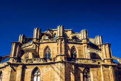 Low angle view of ornate building against clear blue sky