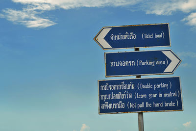 Directional sign against sky