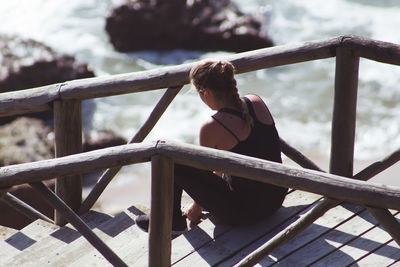 Woman sitting on railing