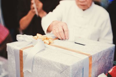 Midsection of woman holding ice cream on table