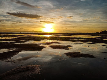 Scenic view of beach against sky during sunset