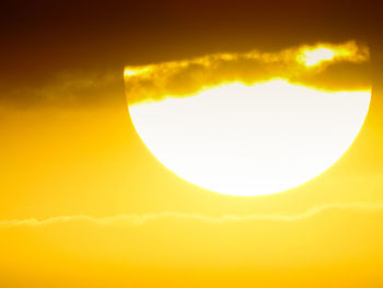 Low angle view of yellow moon against sky during sunset