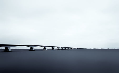Bridge over sea against clear sky