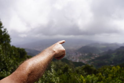 Midsection of person against tree against sky