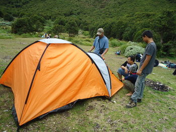 People by tent on mountain