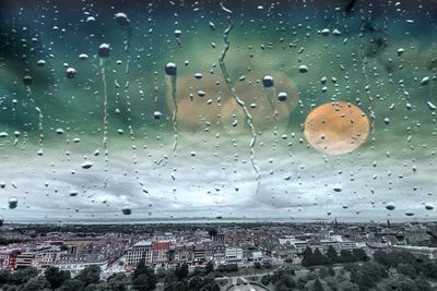 Raindrops on glass window in city