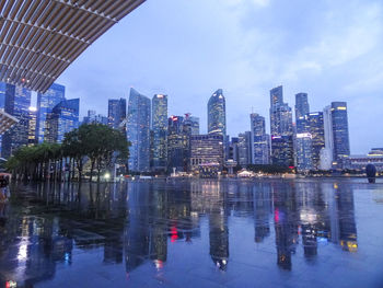 Digital composite image of illuminated buildings by swimming pool