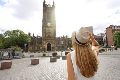 Back view of beautiful woman visiting in the city of manchester in england, united kingdom.