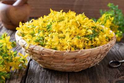 Close-up of yellow flowers in basket on table