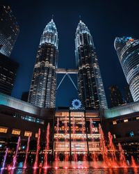 Low angle view of illuminated buildings against sky at night