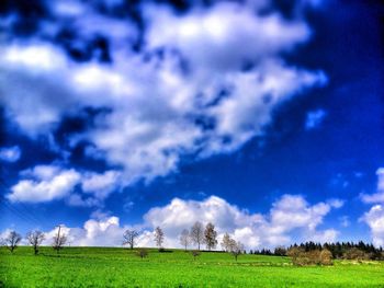 Scenic view of grassy field against cloudy sky