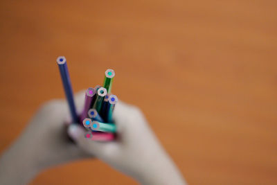 Close-up of hand holding colored pencils