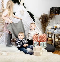 Three children kids playing between christmas gift boxes in a decorated house.merry christmas 