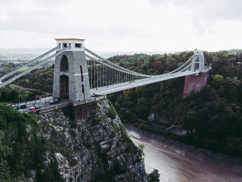 Bridge over river against cloudy sky