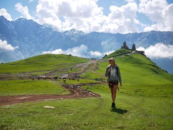 Full length of woman walking on field against sky